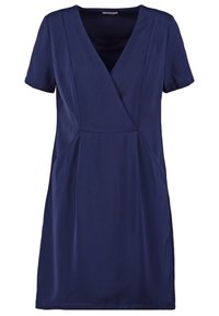 Tummansininen lyhythihainen mekko, jossa on V-pääntie, pehmeää kangasta, liehuva malli ja hienovaraiset saumat sivuilla lisäyksinä.