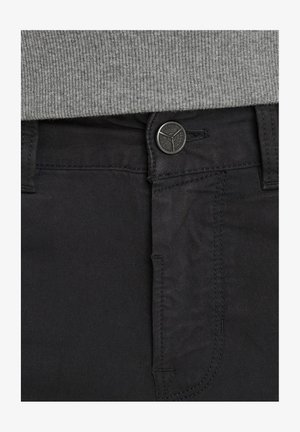 Pantalones de algodón negros con una textura suave, que cuentan con un cierre de botón y cremallera, detalles de costura sutiles y bolsillos frontales estándar.