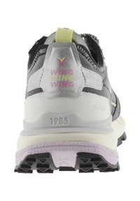 Sneaker nera e argento con materiale textura, collare imbottito e un accento giallo sul tallone. "WING" stampato in rosa e grigio. Suola intermedia bianca.