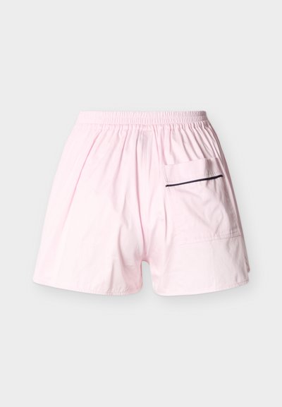 Shorts rose clair avec une ceinture élastique et une grande poche arrière équipée d'une fermeture éclair horizontale foncée.