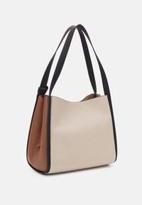 Skórzana torebka z beżowym korpusem, brązowym bocznym panelem i czarnymi paskami. Charakteryzuje się gładką teksturą oraz usztywnionym, pojemnym kształtem.