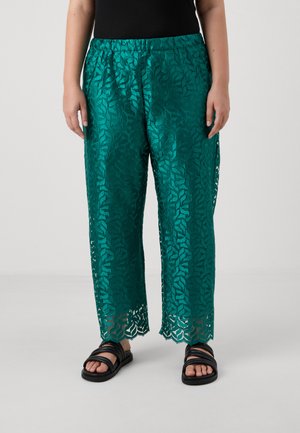 Teal, textuur lace culottes met een elastische tailleband en een uitgesneden bladerenpatroon. Gecombineerd met zwarte sandaletten met bandjes.