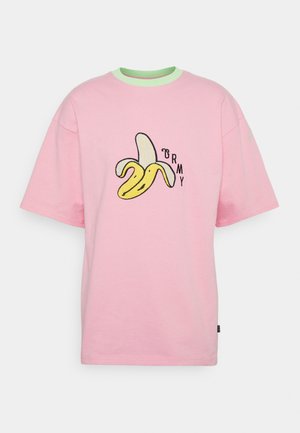 Lyserød T-shirt med grøn krave, med en skrællet banan-grafik og bogstaverne GRMY på forsiden.