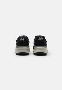 Černé a šedé sportovní boty s texturovaným svrškem z nubuku a síťoviny, obsahující polstrovaný límec a šedou gumovou podrážku. Logo je viditelné na zadní straně.