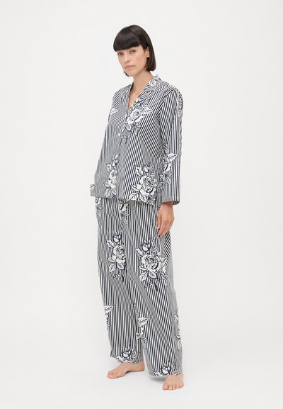 Set di pigiama a righe in navy e bianco, con motivi floreali. La parte superiore ha un colletto e maniche lunghe; i pantaloni sono larghi con uno stile coordinato.