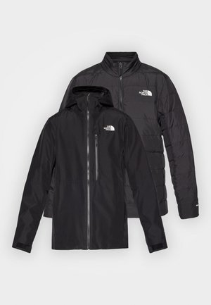 Black outdoor jackets stacked: a waterproof coat with a hood and zippered pockets over a puffy insulated jacket with horizontal stitching.