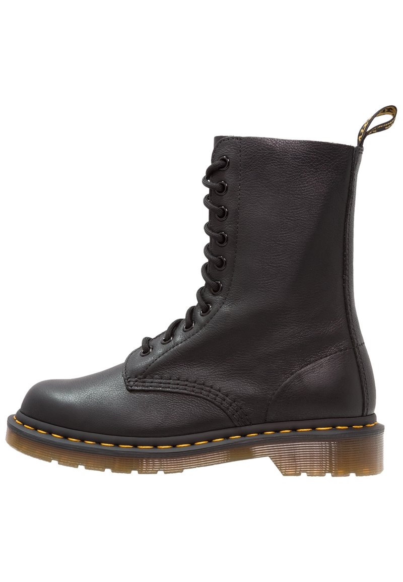 Botte de combat en cuir noir à lacets avec surpiqûres jaunes, semelle épaisse translucide et languette en tissu à l’arrière.