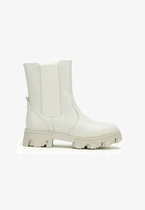 Off-white chunky sole ankle boot with elastic side panel and pull tab, smooth leather upper, and rugged treaded outsole.