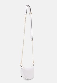 Bílá kožená crossbody taška zaobleného tvaru, s zlatým řetízkem a kontrastními černými akcenty na rukojeti.