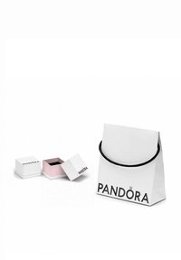 Busta di carta bianca con manico nero, etichettata "PANDORA." Due piccole scatole regalo: una bianca con interno nero, l'altra rosa con interno nero.