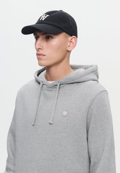 Gray hoodie with drawstrings and a small patch. Black cap with an embroidered logo. Smooth cotton texture, casual design.