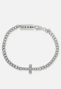 Stříbrný náramek s řetízkem se křížem zdobeným průhlednými krystaly a obdélníkovou destičkou s nápisem "ICON." Zapínání na zacvaknutí.