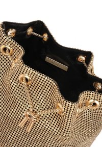 Borsa a secchiello in rete dorata con rivestimento in tessuto nero, caratterizzata da dettagli in metallo dorato e catena per la chiusura. L'interno include l'etichetta del marchio.