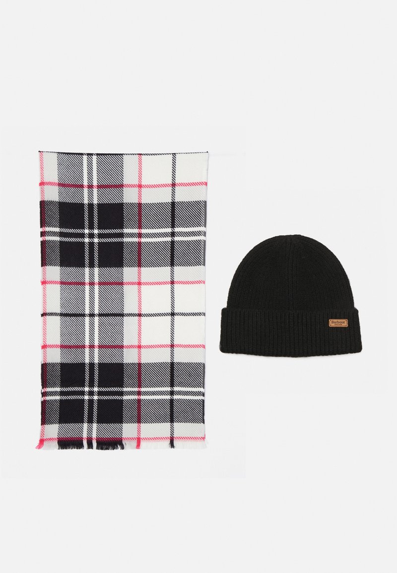 Căciulă tricotată neagră cu o etichetă mică maro lângă o eșarfă albă cu un model în carouri alb-negru, gri și roz, pe un fond alb.