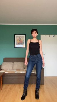 Keha järgivad musta värvi tank top ja tumesinised kitsad teksad, millele on kombineeritud mustad paeltega pahkluu saapad. Sile kangas ja vormiline lõige.