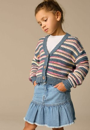 Mønstret strikket cardigan i flere farver med stribede detaljer, V-udskæring, tre knapper og ribbede manchetter, parret med en udvidet denimnederdel.