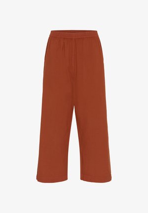 Kalhoty širokého střihu v barvě rezavé, vyrobené z lehkého materiálu. Mají elastický pas a jednoduchý design bez dalších ozdob.