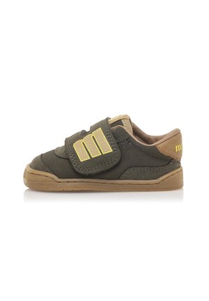 Baskets en daim vert avec fermeture Velcro, accents beige, semelle en caoutchouc et détail de logo sur la sangle. Design bas adapté pour un usage décontracté.