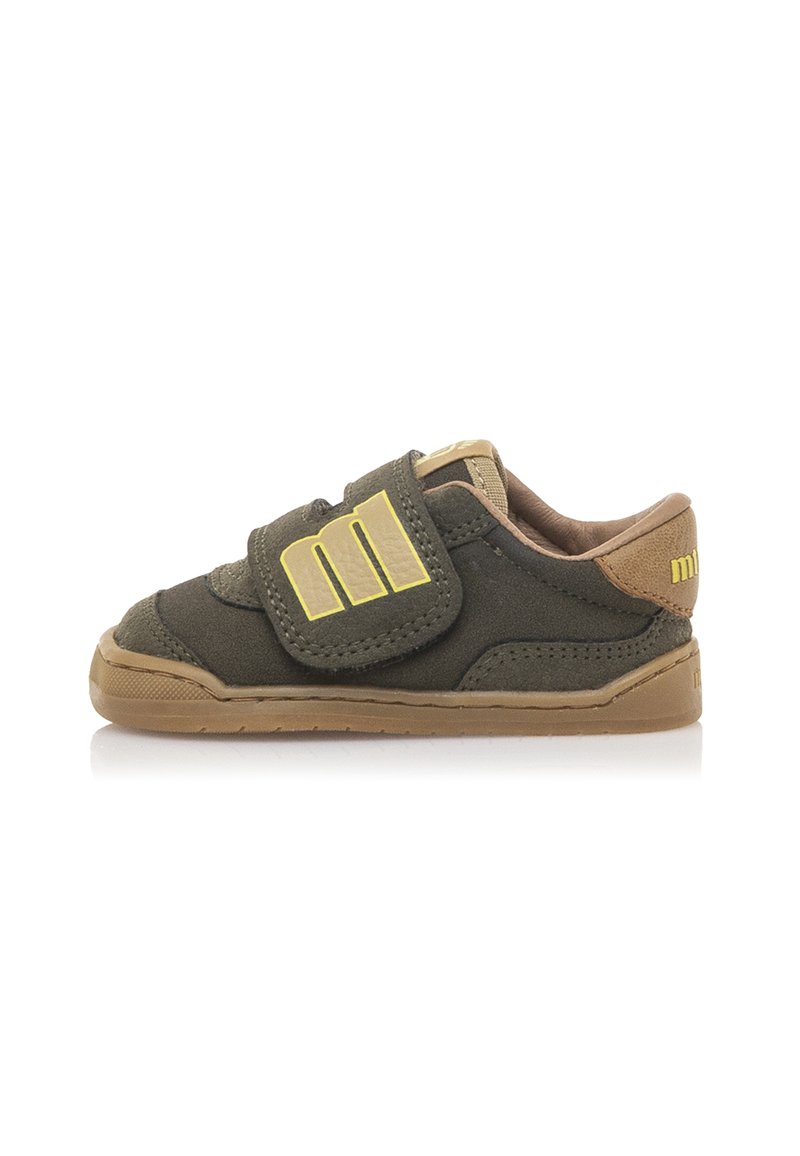 Baskets en daim vert avec fermeture Velcro, accents beige, semelle en caoutchouc et détail de logo sur la sangle. Design bas adapté pour un usage décontracté.