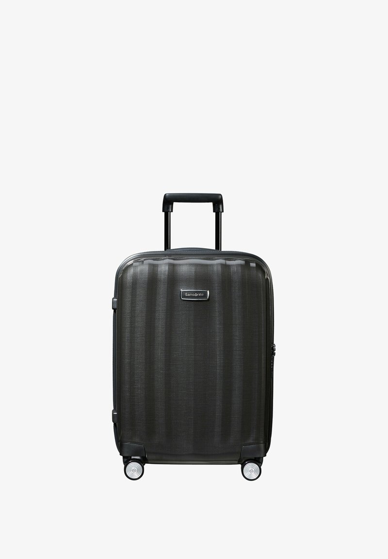 Hard-shell carry-on suitcase in dark gray with textured finish, two wheels, a telescopic handle, and a small brand logo on the front.