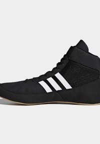 Black high-top athletic shoes featuring a mesh upper, rounded toe, and three white stripes on the side. Rubber sole with a textured finish.