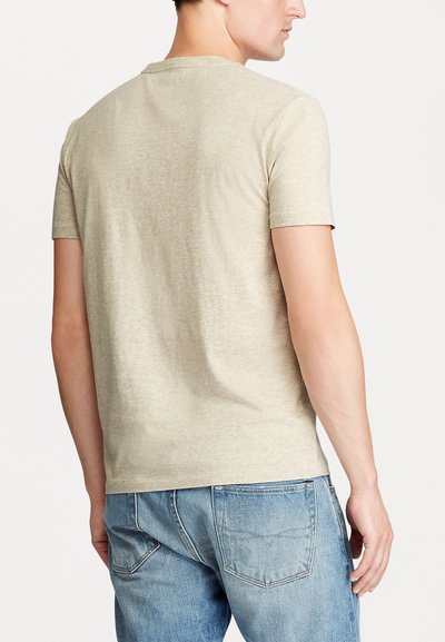 Light beige short-sleeve T-shirt made of soft fabric, featuring a classic crew neckline and a relaxed fit, shown from the back.