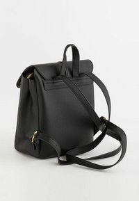 Mochila negra de cuero texturizado con correas ajustables, asa superior y herrajes en tono dorado. Diseño compacto con una forma estructurada.