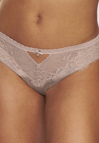 Dort gibt es einen Spitzen- und Satin-Thong in sanftem Beige. Er verf�ügt über florale Spitzenverzierungen, eine kleine Schleife und einen Steinakzent vorne. Der dünne Bund hat gewellte Kanten.