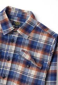 Blauw, bruin en crème geruite flanellen blouse met een omgevouwen kraag, knoopsluitingen en een borstzak. Zachte textuur en ruitpatroondesign.