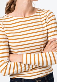 Długi rękaw w poziome pomarańczowo-białe paski, z dekoltem łódkowym i miękką, elastyczną tkaniną z bawełnianej mieszanki.