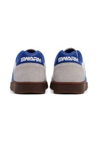 Niebieskie sneakersy z zamszu i siateczki z brązową gumową podeszwą. Zawierają logo "SWARM" na białym tle z tyłu oraz teksturowane akcenty.