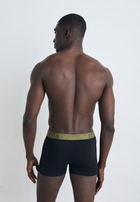 Sorte boxershorts med et mønstret olivengrønt liv, der viser et kropsnært design. Stoffet virker glat og strækbart.