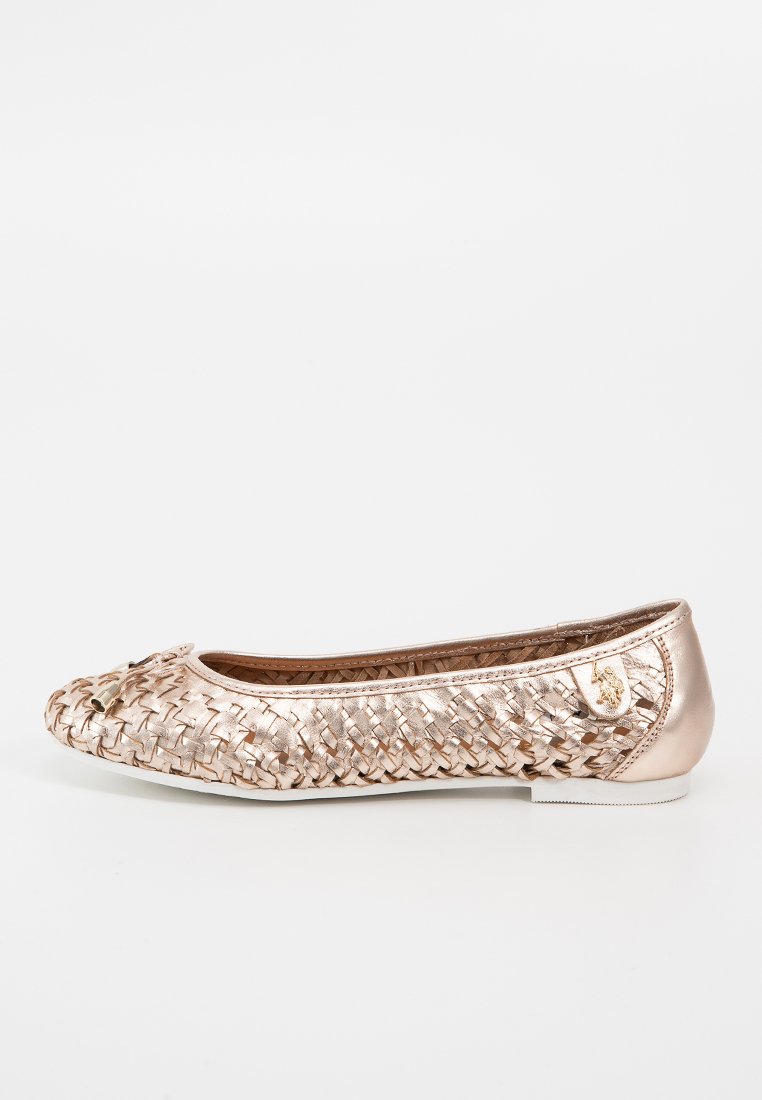 Ballet flat tressé en rose doré métallique avec un détail en nœud et un petit emblème sur le talon, avec une semelle blanche.