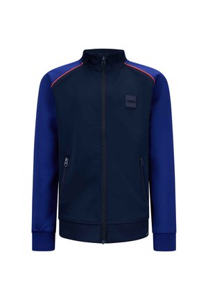 Marine blauw zip-up jack met contrasterende blauwe mouwen en rode accenten, gemaakt van gladde stof; bevat zij-zipzakken en een opstaande kraag.