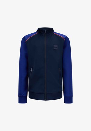 Marineblaue Zip-Jacke mit kontrastierenden blauen Ärmeln und roten Akzenten, aus glattem Stoff; verfügt über seitliche Reißverschlusstaschen und einen Stehkragen.