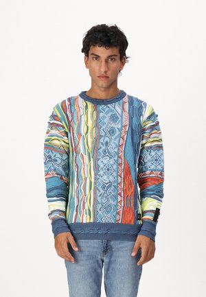 Kleurvolle sweater met lange mouwen, featuring een mix van blauw, rood, geel en gestreepte ontwerpen, met geribbelde manchetten en onderrand.