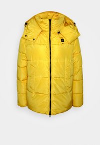 Gele gewatteerde jas met een hoge kraag en een capuchon. Voorzien van een ritssluiting aan de voorkant, zijzakken en zwarte hardware-accenten.