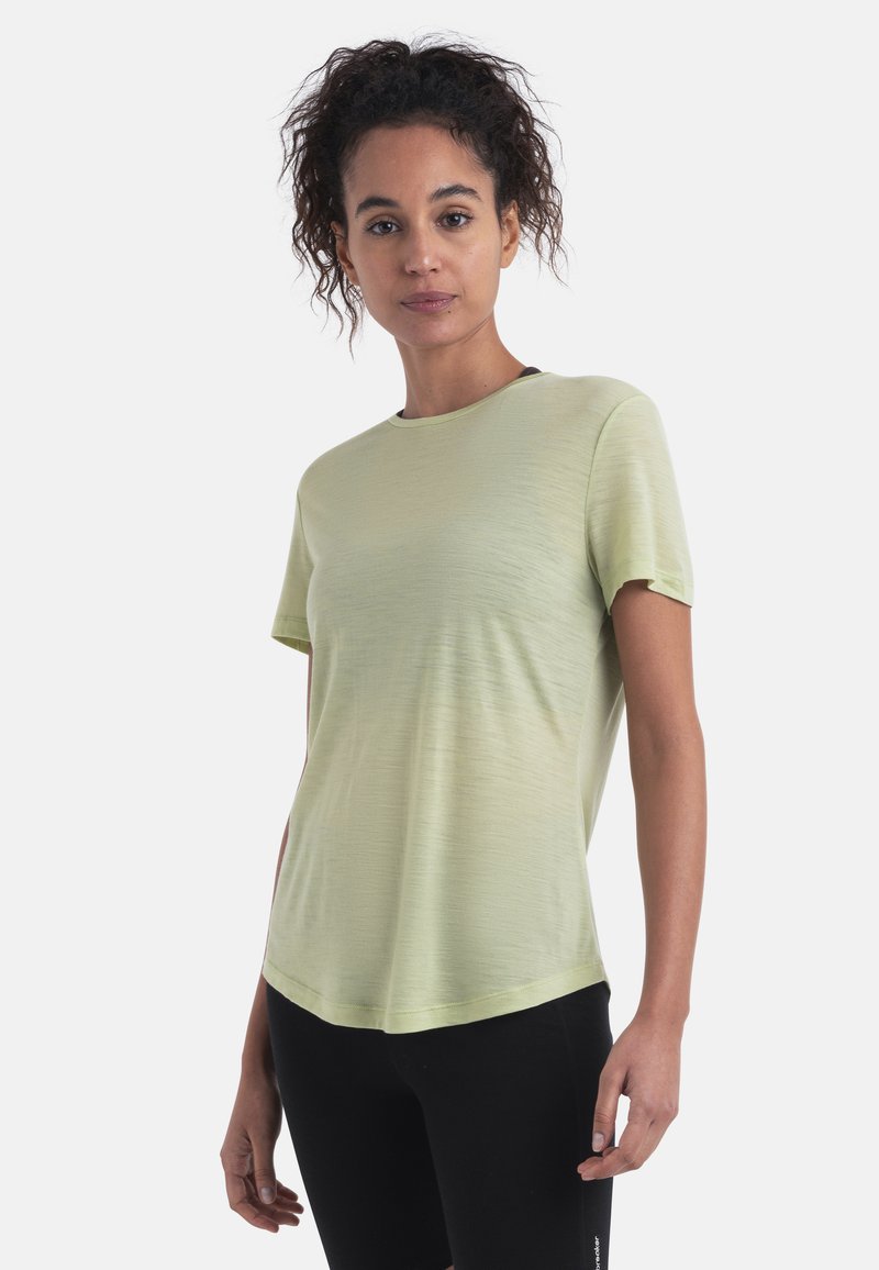 Camiseta de manga corta verde claro con cuello redondo y un corte holgado, que presenta una textura suave y un dobladillo ligeramente curvado.