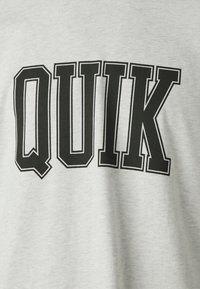 Šedá mikina s výrazným černým nápisem "QUIK", jednoduchý design a hladká textura.