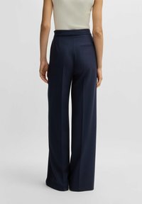 Marinblå vida byxor i en mjuk tygkvalitet med hög midja och en bakficka, med en ren design och skräddarsydd passform.