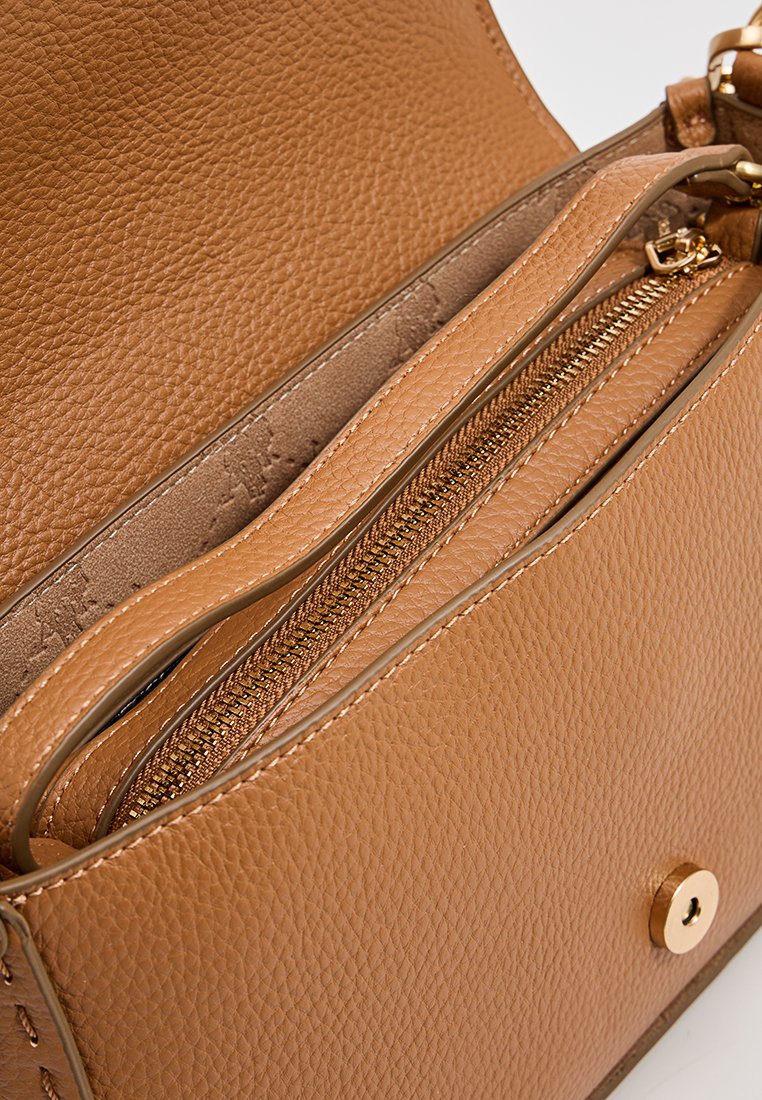 Sac à main en cuir tan avec une finition texturée, comportant une poche intérieure zippée et des accents en métal doré. Forme compacte et structurée.