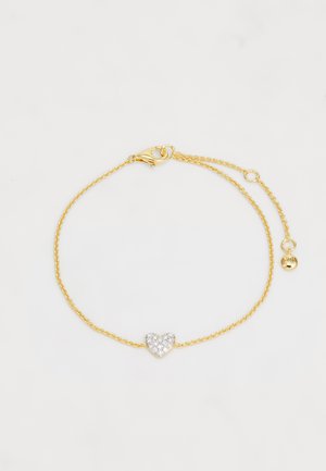 Kuldne käevõru, millel on keerutatud aheladisain, ja millel on hõbedane südamekujuline ripats, mis on kaunistatud selgete kristallidega. Krokodillikinnitusega sulgemine.