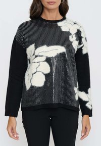 Maglione nero con motivo floreale bianco; il design presenta paillettes nella parte superiore, un tessuto a maglia testurizzato a contrasto e maniche lunghe.