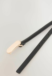Mustat nahkavyöt, jossa on tyylikäs kultainen metallisolki, joka on sileäpintainen ja jossa on useita säätöreikiä vyön varrella.