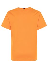 Oranžové bavlněné tričko s kulatým výstřihem a krátkými rukávy. Na zádech je malý třibarvý akcent u výstřihu. Hladká textura.