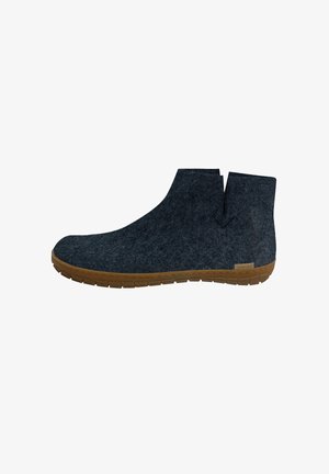 Harmaat nilkkurit, joissa on pyöreä kärki ja minimaalinen muotoilu. Kumipohja tuo kontrastia. Edessä on halkio, joka helpottaa pukemista.