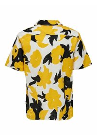 Camicia a maniche corte con base bianca e grande stampa floreale gialla e nera, colletto a punta e vestibilità comoda.