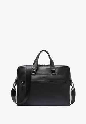 Czarna skórzana teczka z podwójnymi uchwytami, odpinanym paskiem na ramię oraz przednią kieszenią na suwak, umieszczona na białym tle.