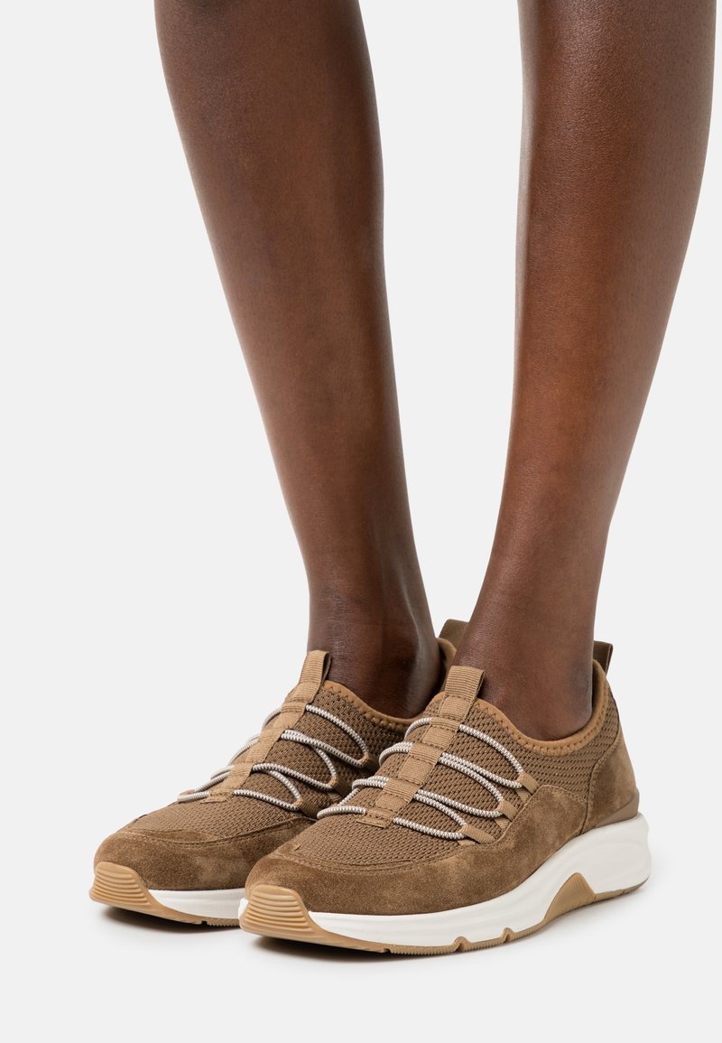 Bruna mocka- och nät-sneakers med elastiska snören, gummisulor och en texturerad finish. Rund tå och vadderad krage för komfort.