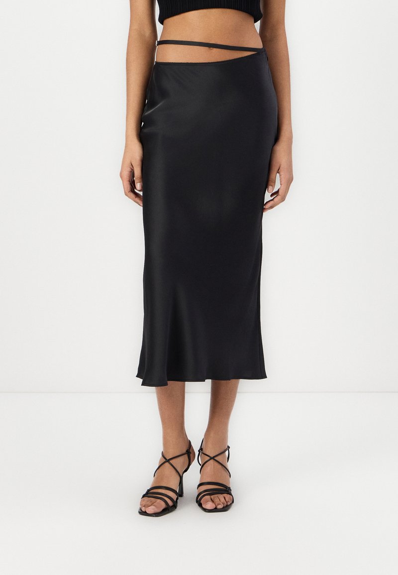 Jupe midi en satin noir à coupe slim, dotée d'un design asymétrique et de détails de sangle ajustable à la taille.